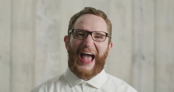 Close Up Young Mad Angry Man in Basic White Shirt Looking at Camera Screaming