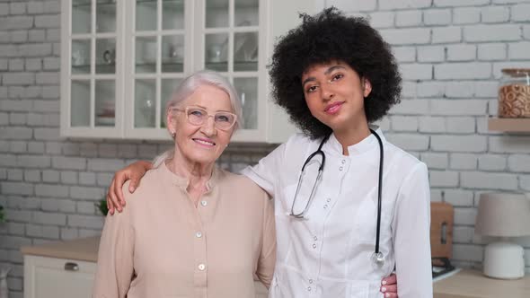 Afro American Woman Doctor and Patient Senior Woman Standing and Smiling at Home alt