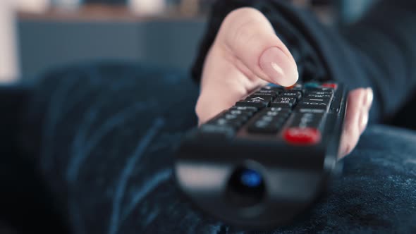 Closeup of a Woman Hand with Manicure Switches Channels Watch Tv at Home