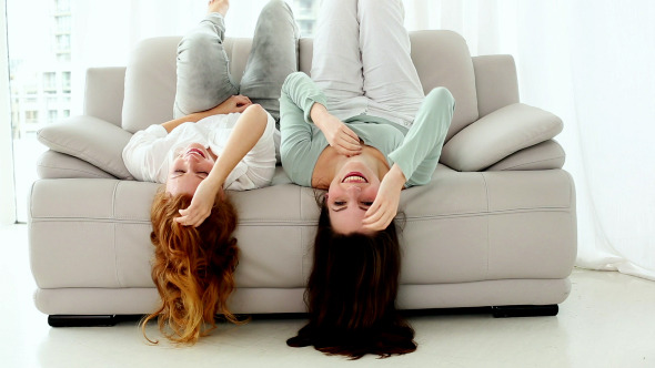Two Lovely Women Lying Head First On Couch