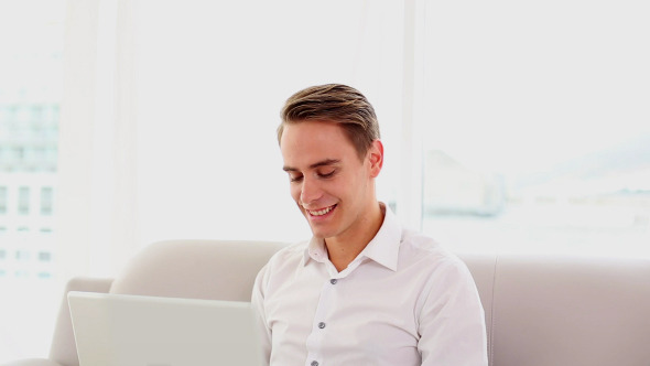 Cheering Attractive Man Using His Laptop Sitting