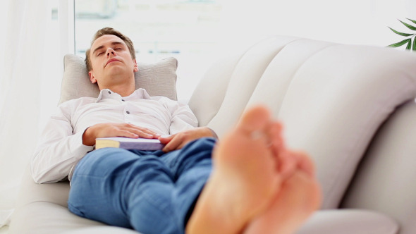 Attractive Young Man Lying On Couch While Sleeping