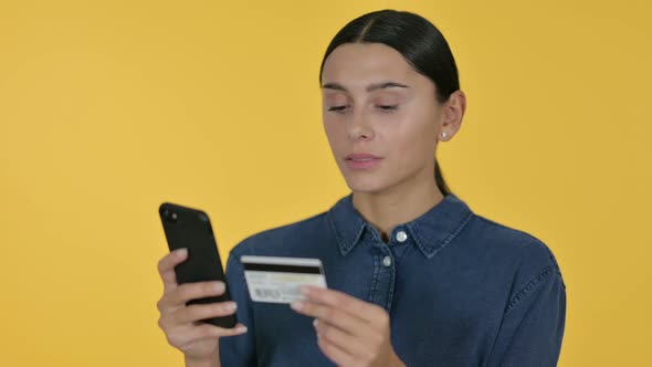Online Shopping on Smartphone By Latin Woman, Yellow Background  alt