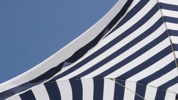 Fabric of umbrella protection from the sun slow motion  moving on wind 1080p FullHD footage - Under  alt