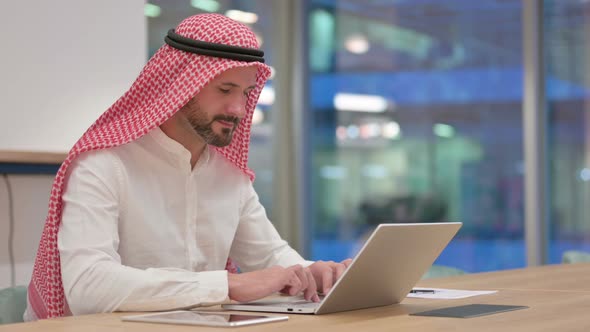 Thumbs Down By Serious Arab Businessman with Laptop alt