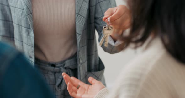 Handing Over the Keys of a House By a Real Estate Agent to a Young Couple in Love Who Rented or alt