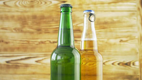 Two beer bottles rotating on wood texture surface. 