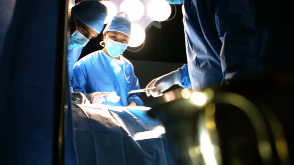 Surgeons performing operation in operation room alt