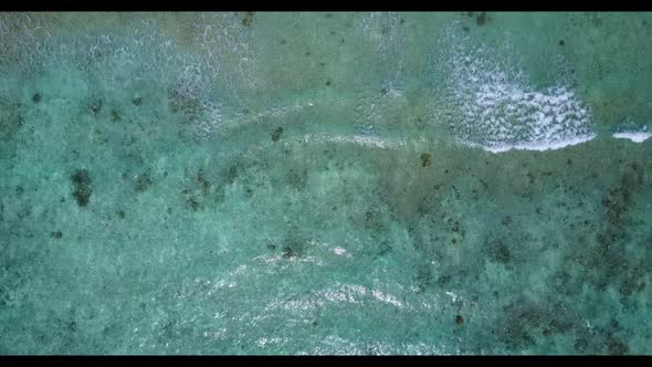 Aerial top down abstract of perfect tourist beach break by blue lagoon and white sandy background of alt