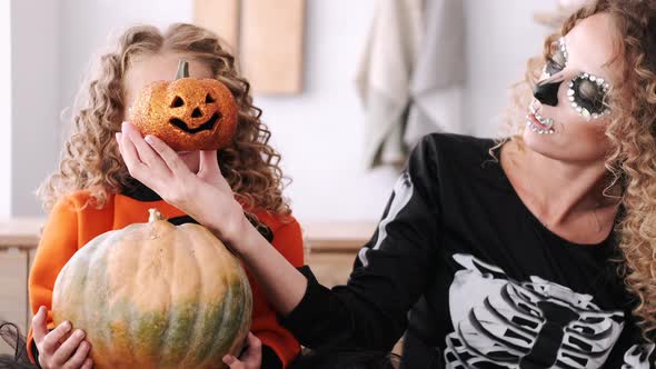 Mother and Daughter with Curly Hair Wearing Halloween Costumes alt