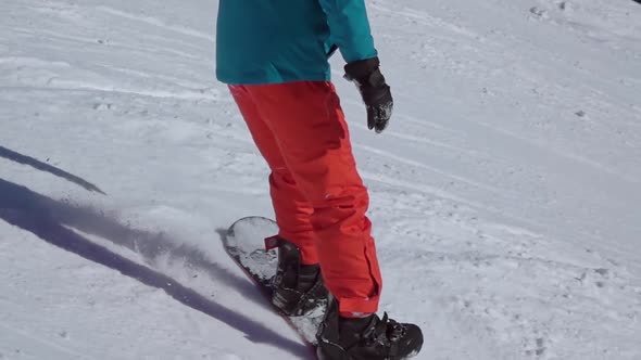 Snowboarder in a Red-Blue Suit on a Ski Slope