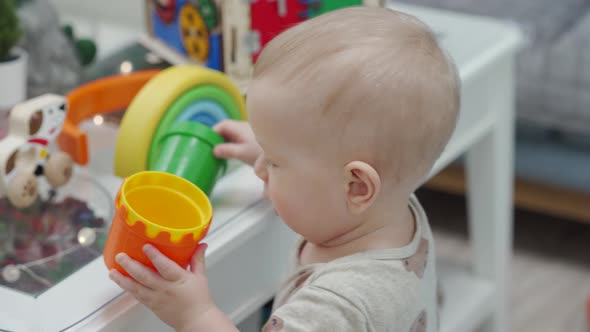Child Having Fun Playing with Plastic Stacking Cups 10 Month Old Caucasian Cute Little Toddler at alt