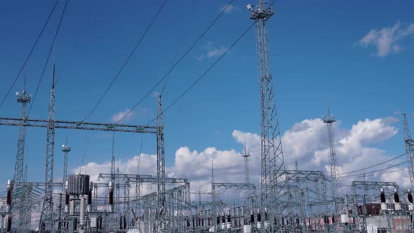 Timelapse High voltage power plant with tall pylons and voltage distribution cables alt