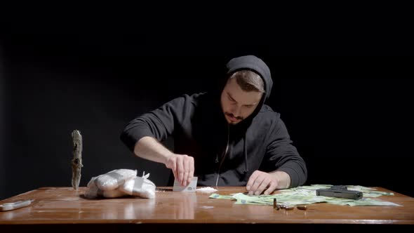 Man Forms Lines Of Cocaine Powder On The Table For Snorting. Illegal Drug And Dirty Money Concept. m alt