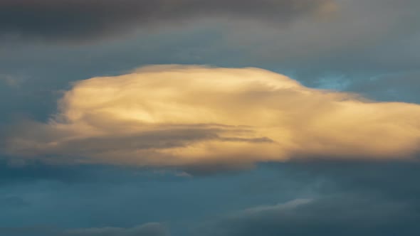 Golden Clouds Illuminated by Disappearing Rays at Sunset Floating Over Sky