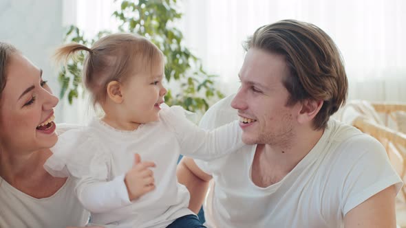 Young Loving Parents Mom Mother and Happy Father Hug Cuddle Embrace Little Girl Daughter Toddler alt