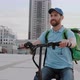 Man Courier Food Delivery with Thermal Backpack Rides the Street on an Electric Scooter Deliver - VideoHive Item for Sale