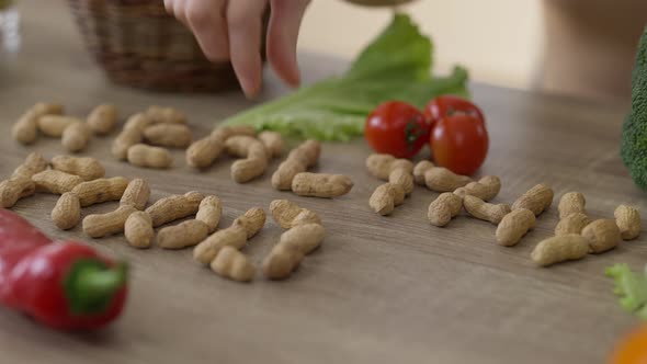 Female Hand Putting Almond on Table Writing Healthy Food alt