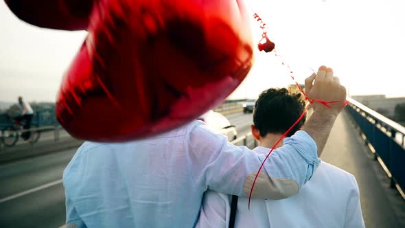 Smiling Couple in Love with Balloons on Sunset