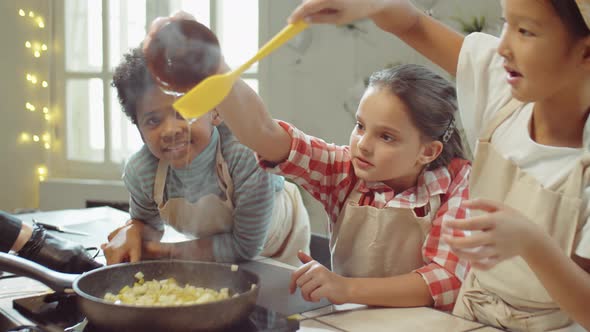 Kids Adding Honey to Fruit in Pan during Cooking Class alt