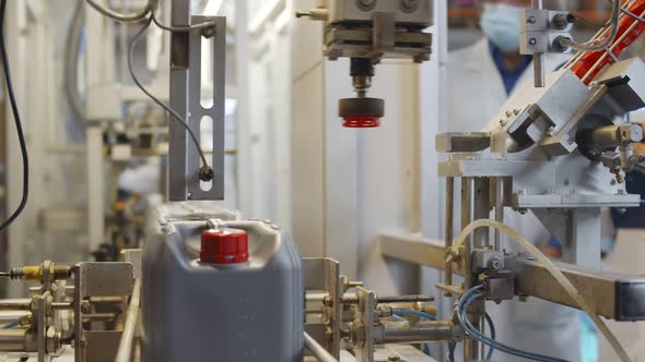 Plastic Containers Moving on Conveyor Belt of Auto Capping and Labeling Machine at Chemical Factory alt
