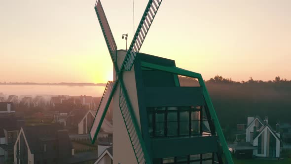 Decorative Windmill Townhouse at Dawn with Fog That Hangs in Layers. Light Haze.