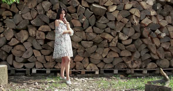 Pretty Girl in Dress Smoking Ecigarette and Exhales on Wood Background alt