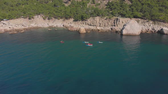 Aerial Shot Group of Kayakers Paddling Down on Mountain River on Kayaks on Summer Day alt