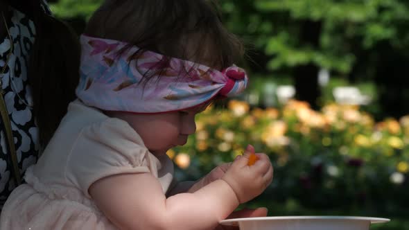 Little baby girl learning to eat by herself alt