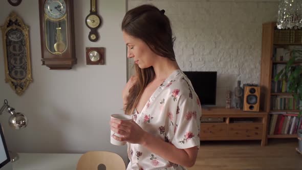 Woman in Pajamas Working Remotely at Home During a Pandemic in Slow Motion alt