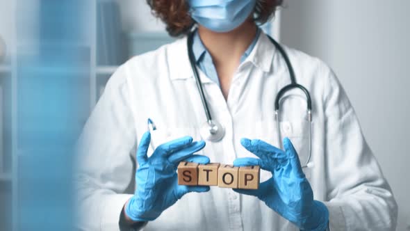 Doctor Is Holding A Stop Sign Gesture Word. The Text Stop Is Held By The Hands Of A Medical Worker alt