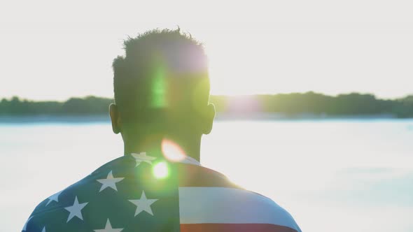 Back View Afroamerican Man Ethnic Black with USA Flag on Shoulder Looks Sunrise alt