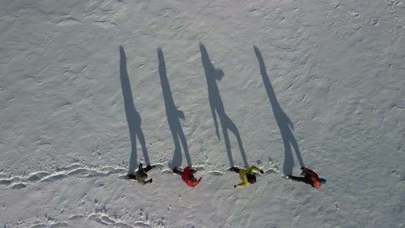 Large Shadows in the Snow From Four Travelers