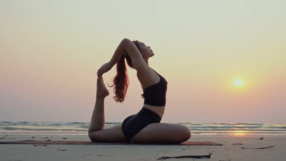 Vacation of Attractive Asian woman relaxing in yoga king pigeon pose on the sand and beach alt