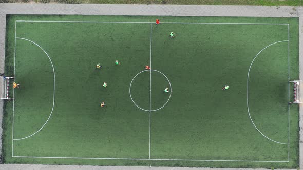 Top view of a sports football field with players playing football