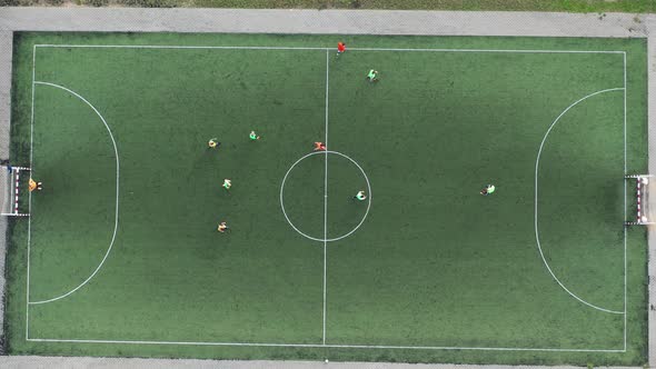Top view of a sports football field with players playing football alt