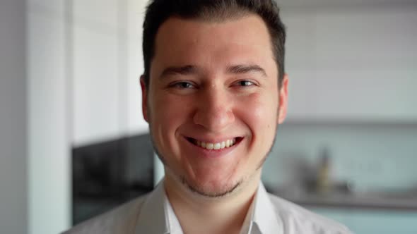 Very close up portrait young adult man looking at camera and smiling laughing alt
