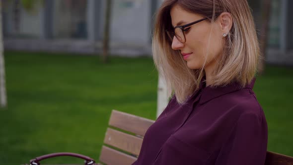 Freelancer manager typing working on laptop remotely outdoor park sitting on a bench. alt