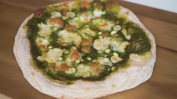 Slow Motion Pan forward from a blurry background to in focus of a delicious homemade Italian pizza w alt