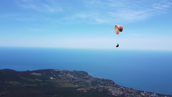 A Paraglider Flies on a Paraglider Against the Backdrop of the Beautiful Peaks alt