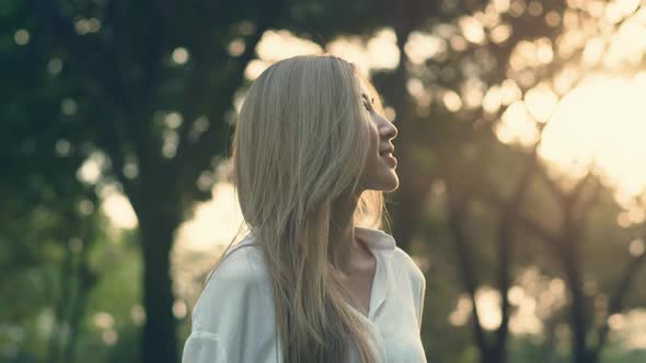 Asian female looking around her enjoying the breeze in the public park.