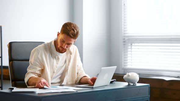 Guy manager assistant with beard looks into paper documents alt