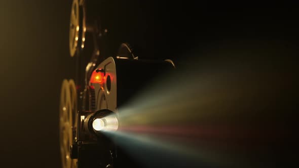 Vintage Movie Projector Projecting Film in a Dark Room alt