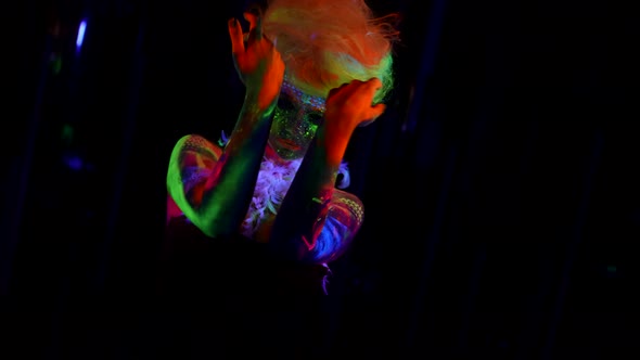 Lady with Eccentric Makeup By Fluorescent Paints and Neon Wig on Head UV Light alt