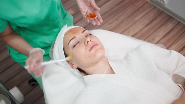 Female Beautician Makes Face Rejuvenation and Cleansing Procedure for Girl alt