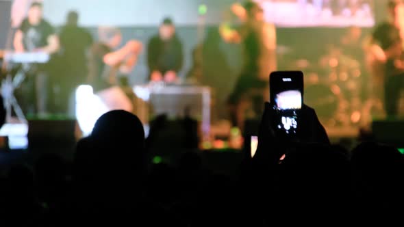 People Filming Rock Concert on Smartphones Silhouettes Crowd of Fans Dancing alt