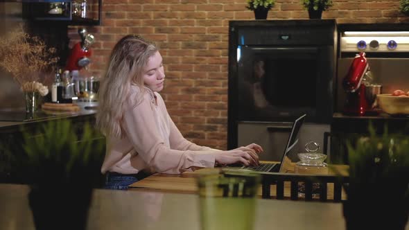 Girl communicates smartphone with client and type on laptop alt