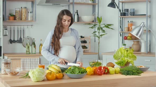 Beautiful Pregnant Woman Happily Preparing a Vegetable Salad The Concept Of Diet alt