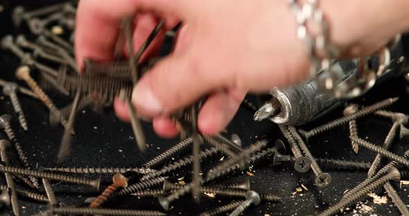 Man hands take in handful self-tapping screws