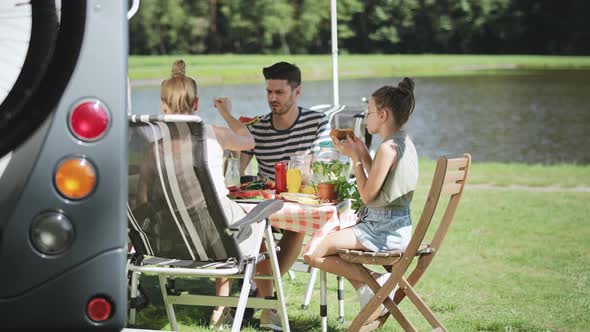 Handheld video of family relaxing during lunch on camper trip. Shot with RED helium camera in 8K. alt